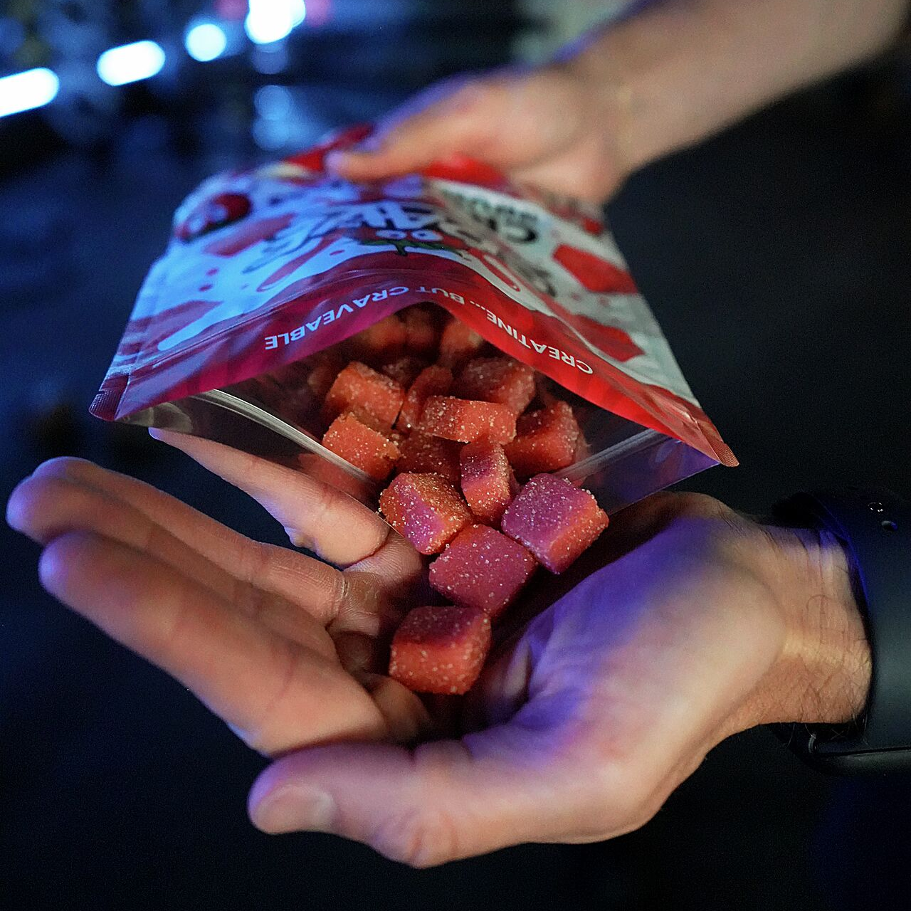 A handful of Crave creatine gummies poured from the bag
